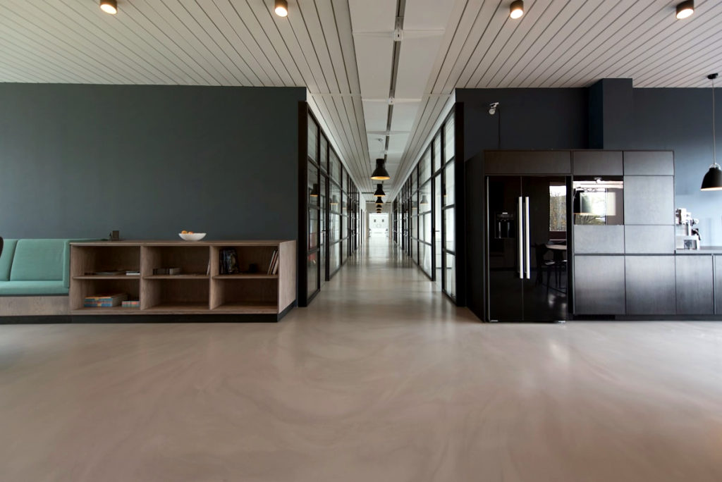 Modern office corridor with glass walls and lighting.